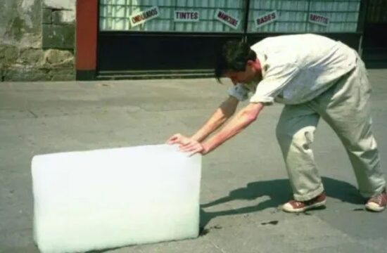烈日下，推着冰块行走的男人